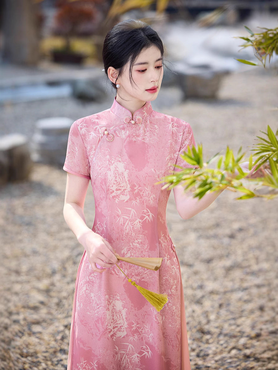 Close-up showing embroidery details and mandarin collar of the Eternal Blush Modern Ao Dai Dress. Soft pink tones complement the model’s gentle, natural styling. Elegant, calm, and romantic.
