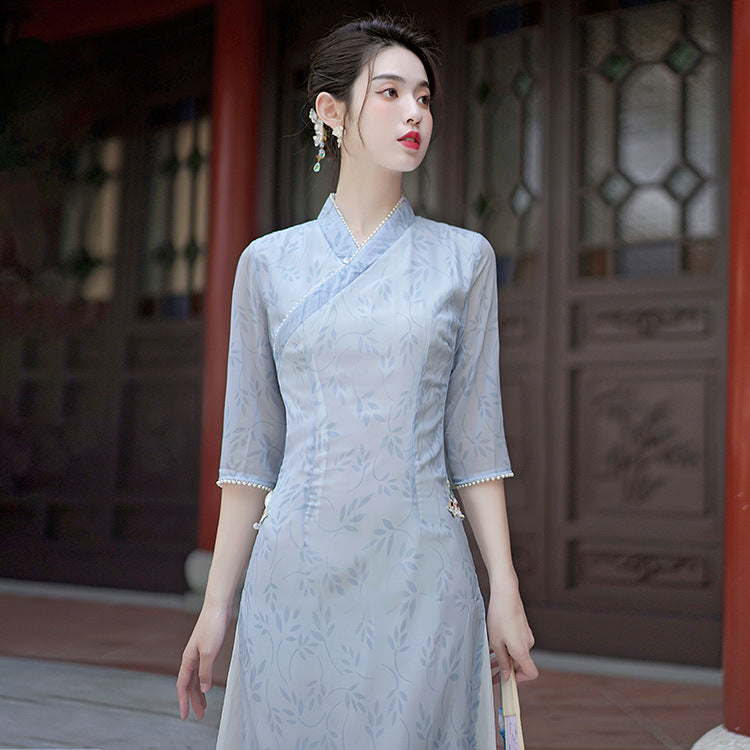 Close-up of the upper bodice showing the wrap-style collar, delicate embroidery, and semi-sheer sleeves.